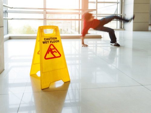 Indiana and Kentucky slip and fall attorney. Person slipping behind wet floor sign.